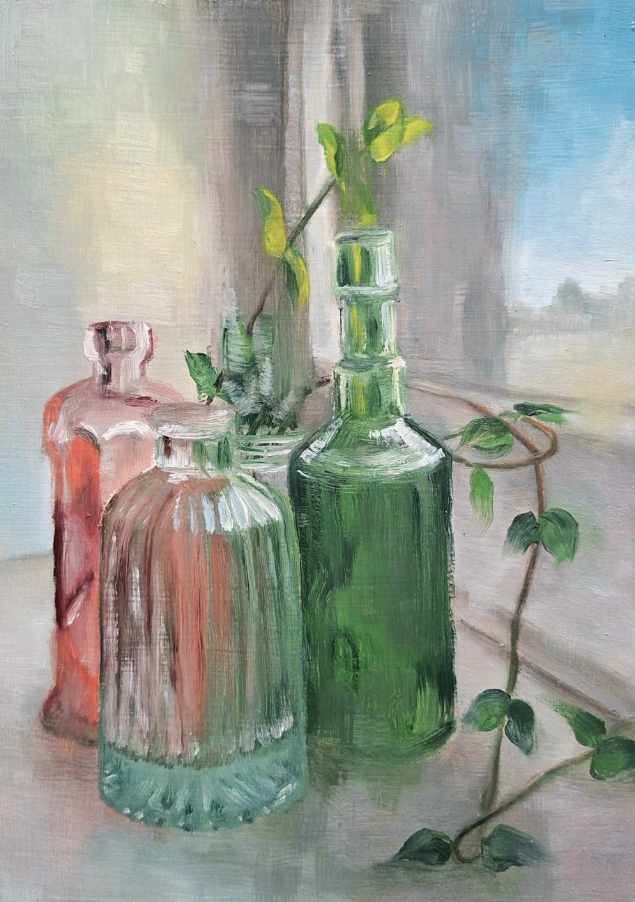 Verschiedenfarbige Flaschen auf einer Fensterbank. Im Hintergrund eine Ranke, die sich Richtung Fenster und in den Vordergrund schlängelt.