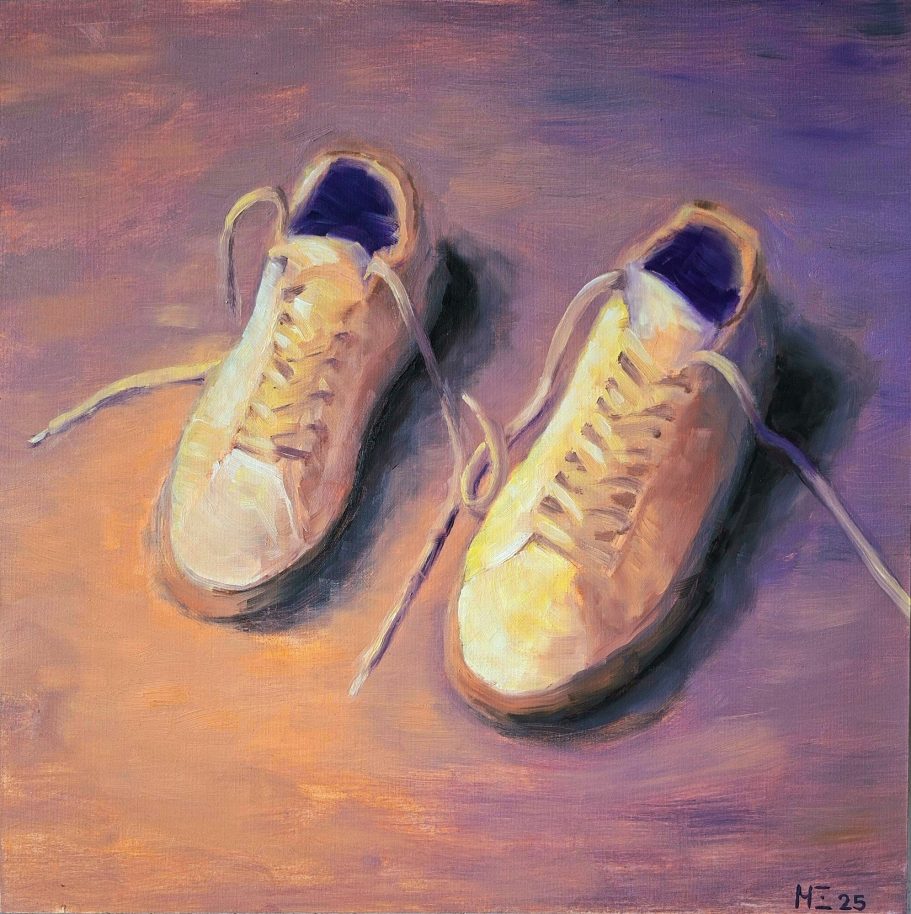 Ein Paar weiße Sneaker im Abendlicht. Sie leuchten orange-violett.