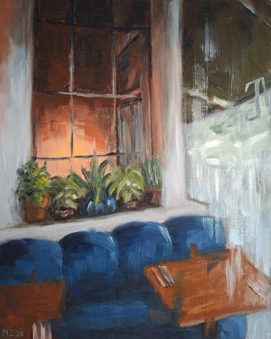 Ein Sofa in einem Restaurant. Fensterplatz. Darüber ein Fenster in eine warm beleuchteten Ecke des Restaurants.