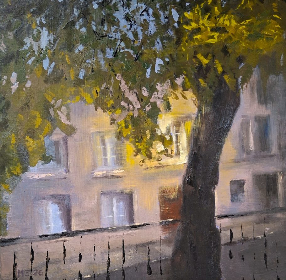 Eine Häuserfront in Paris. Man sieht die Häuser durch einen Baum, der etwas erhöhnt steht. Lampenlicht scheint durch die Blätter.