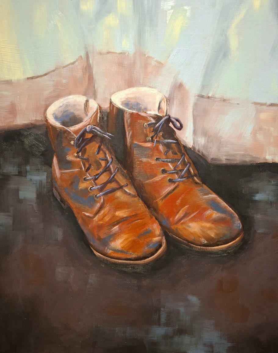 Braune Wanderschuhe vor einem Vorhand. Die Sonne scheint durchden Vorhang.